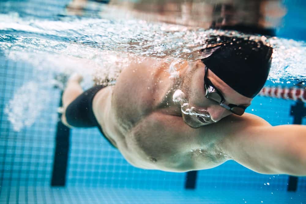 Professional male swimmer practising in swimming pool